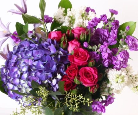 Think spring- lilacs, hydrangea, stock, spray roses and more are included in this beautiful vase arrangement. 
