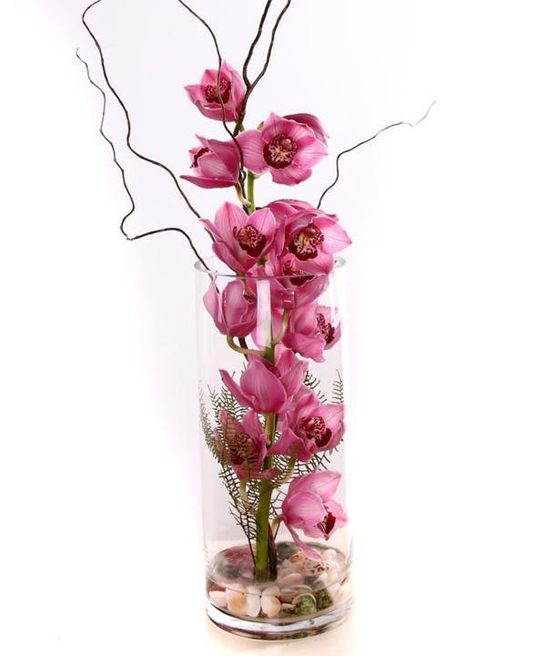 Pink Cymbidium orchids in clear vase