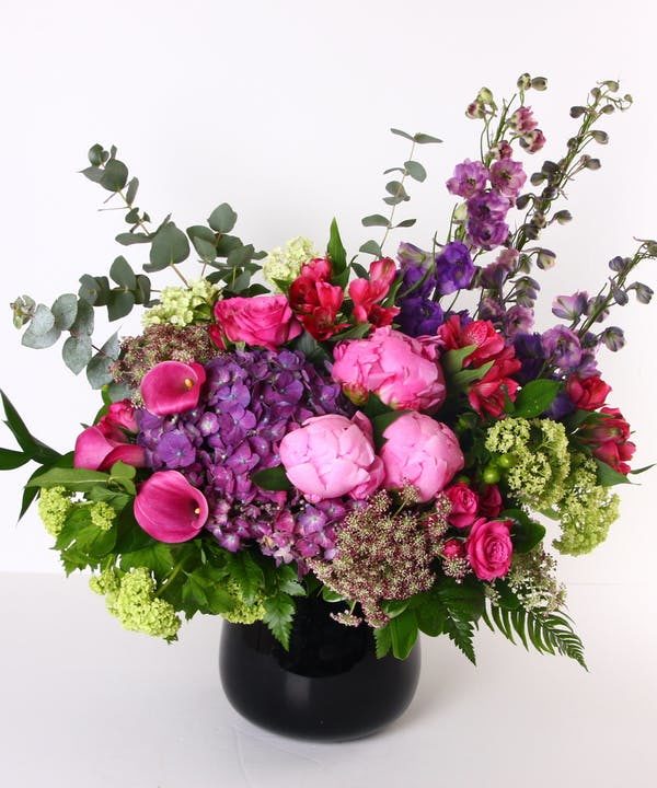 pink peonies and red and purple flowers in a vase