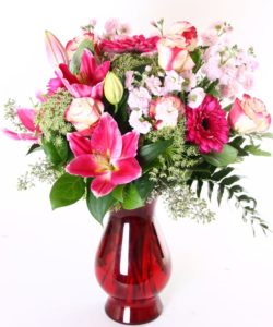 Bright pinks, soft pink, and white flowers are arranged in this impressive vase. Gerbera daisies, lilies, roses, and stock are included. 