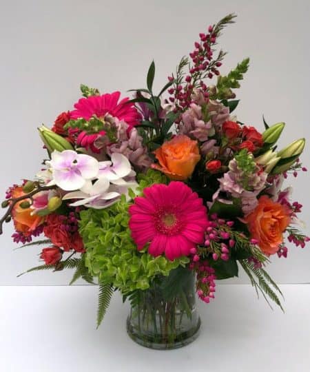 assortment of beautiful flowers with red pinks oragnes and greens